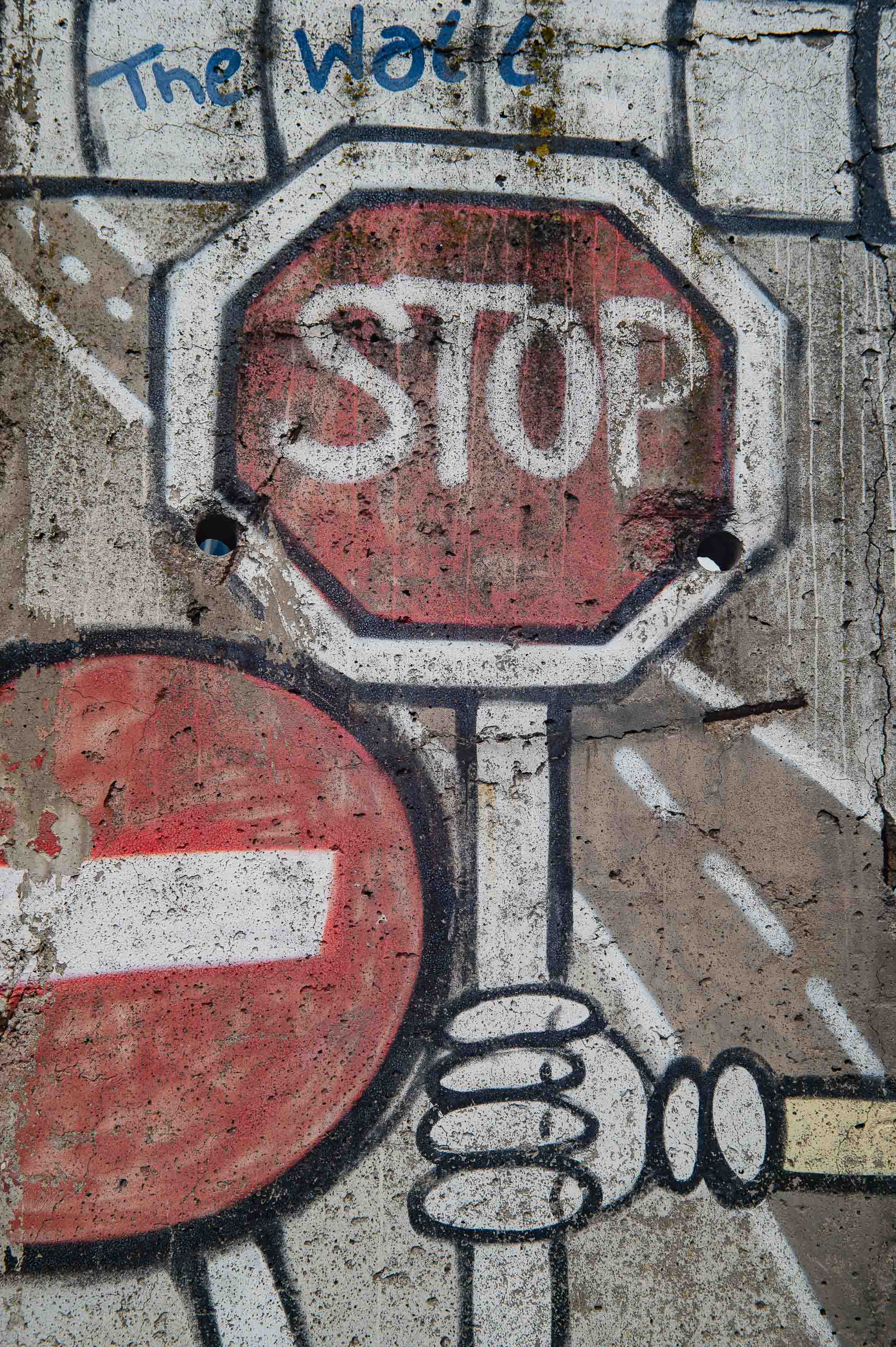 A "Stop" painted on a piece of the Wall: a traffic sign turned into graffiti, and graffiti turned into a symbol.
